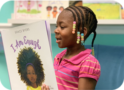 Young girl with braids with colored beads reading a childrens book